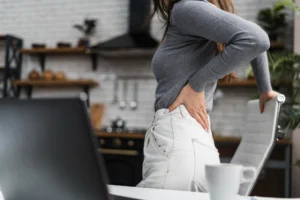 mulher apoiada na cadeira com a mão nas costas